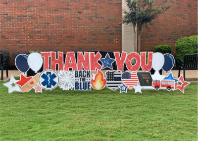 "Thank You - Back the Blue" yard sign - red letters with "Back the Blue" logo in blue impact font beneath, first responders, police, fire department symbols accented with American flag and Bible