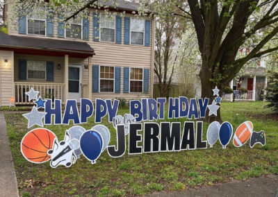 YL Hampton sign - "Happy Birthday Jermal". Bold navy blue and black letters, silver and blue elements (stars and balloons). "We love you". Basketball, football, microphone and video game elements in foreground.