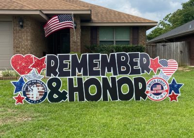 YL Pensacola sign - "Remember & Honor". Bold black letters surrounded by red, white and blue patriotic accents.