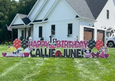 Yard Love CT sign - "Happy 1st Birthday Callie and June!" Glittery pink and black letters surrounded by red and black balloon accents, sparkly pink and black birthday accents (cake, presents, etc.), ladybugs and butterflies